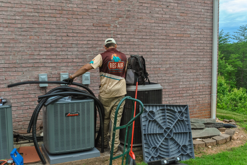 HVAC technician performing professional air conditioner maintenance on a residential AC unit